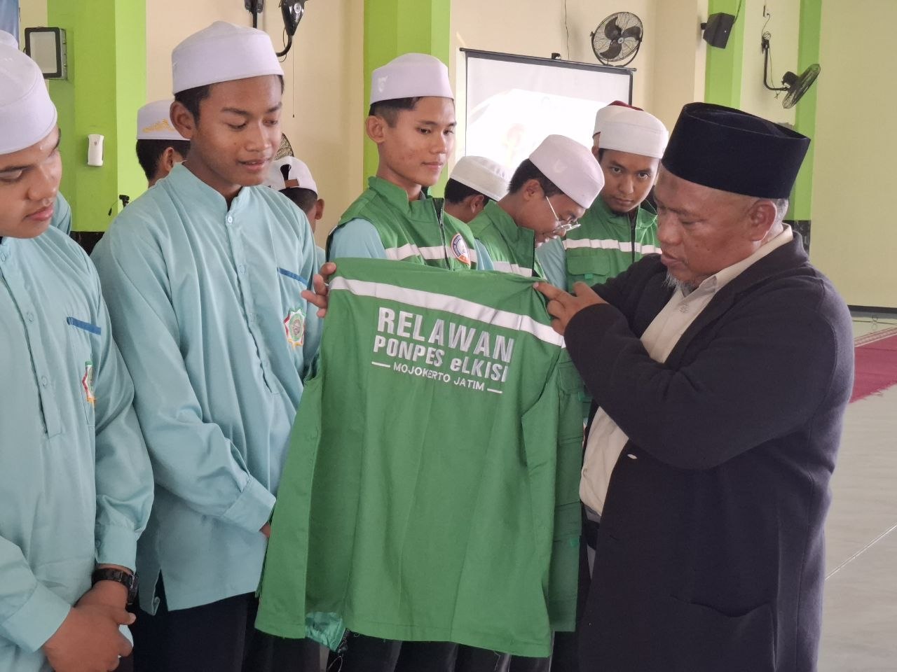 Penyerahan simbolis rompi relawan santri pengabdian SMA eLKISI Mojokerto