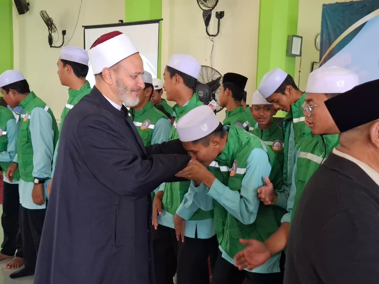 Santri mencium tangan Masyayikh Azhari bertoga dan berimamah