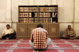 Seorang muslim bertadabbur meresapi keutamaan sabar dalam islam di masjid